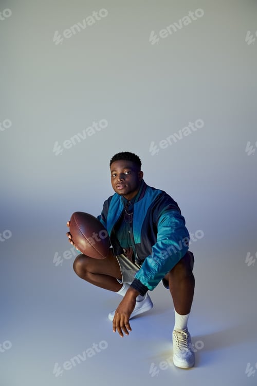 Preview: Stylish Man Crouching With American Football