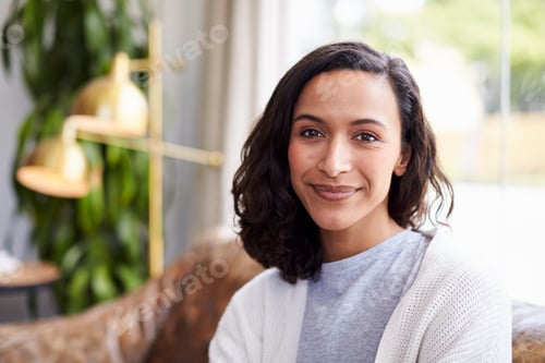 Preview: Young mixed race woman in coffee shop looking to camera
