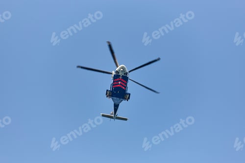 Preview: Helicopter flying under a blue sky from below. Transport