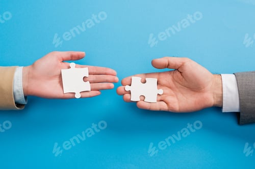 Preview: top view of male and female hands with jigsaw on blue