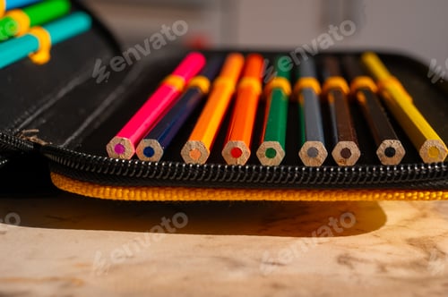 Preview: multi-colored pencils in a schoolboy's pencil case