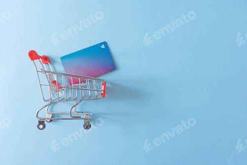 Preview: credit cart in shopping cart on blue background