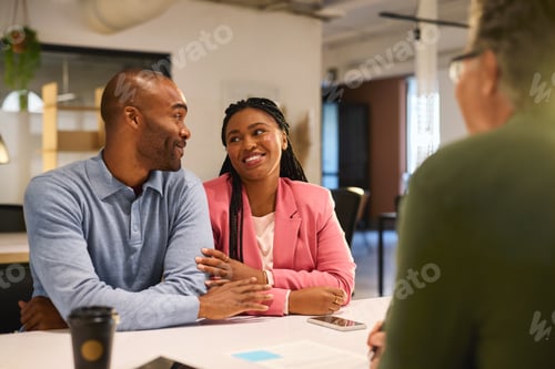 Preview: Happy black couple consulting bank agent for their savings