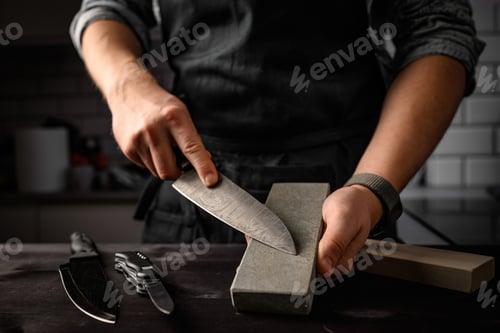 Preview: Man sharpening a knife with sharpen stone tool