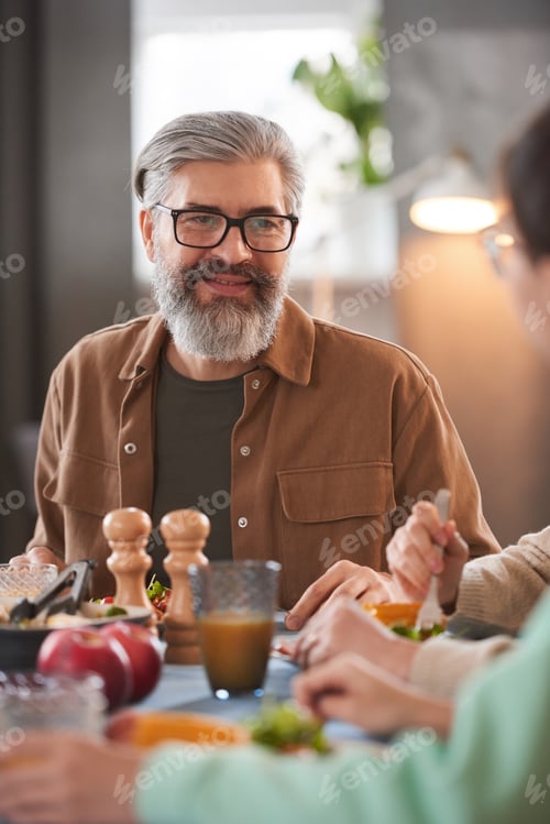 Man with Gray Beard at Table Eating Meal