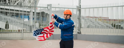 Preview: a patriontic american male worker holding usa national flag outdoors