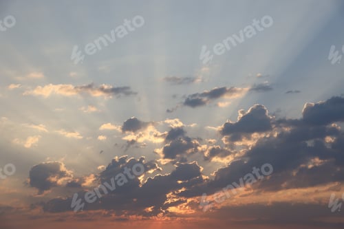 Preview: Beautiful sunrise with warm orange sunlight and beams through blue sky