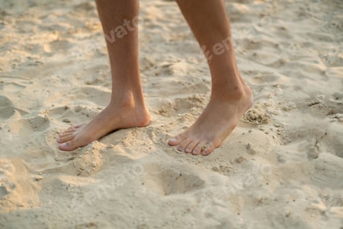 Preview: bare male feet walk on the sandy beach, healthy yoga practice concepts