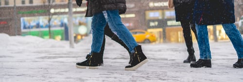 Preview: peoples legs with boots walk in snowy day. fashion concept in the city street f