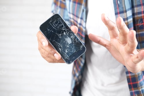 Preview: Close up of man hand holding broken smart phone.