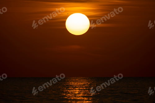 Preview: Ocean sunset. Big white sun on dramatic bright sky background, soft evening horizont