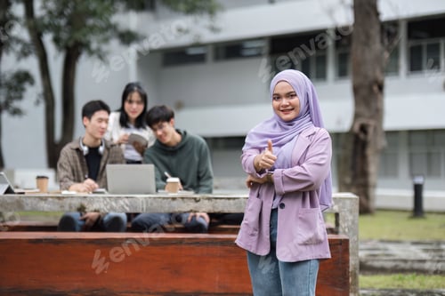 Preview: Portrait of a Muslim student with a fellow student behind him studying in the university garden