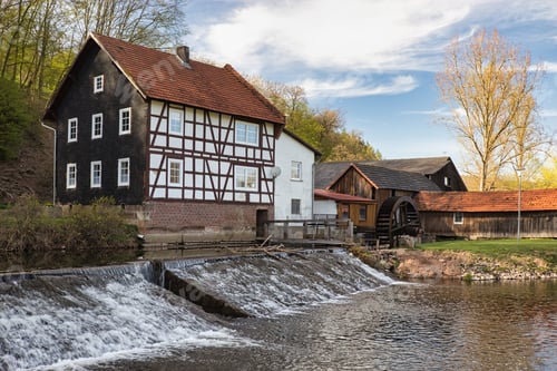 Preview: Humble farmhouse with stables and other buildings near a river with a watermill