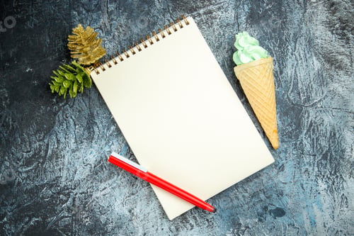 Preview: top view a notebook xmas details red pen ice cream on dark background with copy space