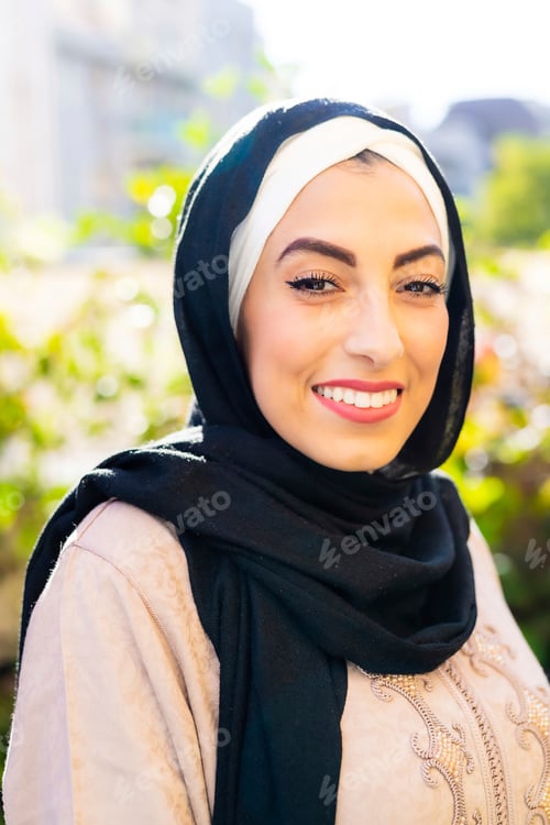 Preview: Smiling woman in a hijab enjoying a sunny day