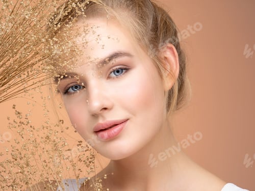 Preview: Blonde girl with a bunch spring dry field flowers near the face