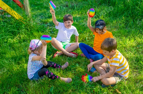 Preview: Children play pop it on the street. Selective focus.