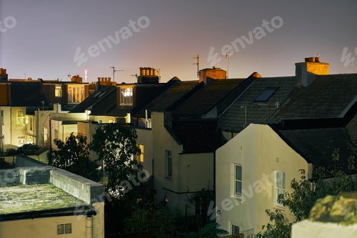 Preview: Elevated view of a row of terraced house roof tops at night, Brighton, East Sussex, England
