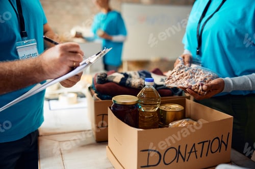 Vista previa: Close up of volunteers packing boxes at donation center.