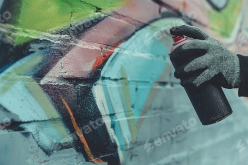 Preview: cropped view of man painting colorful graffiti on wall