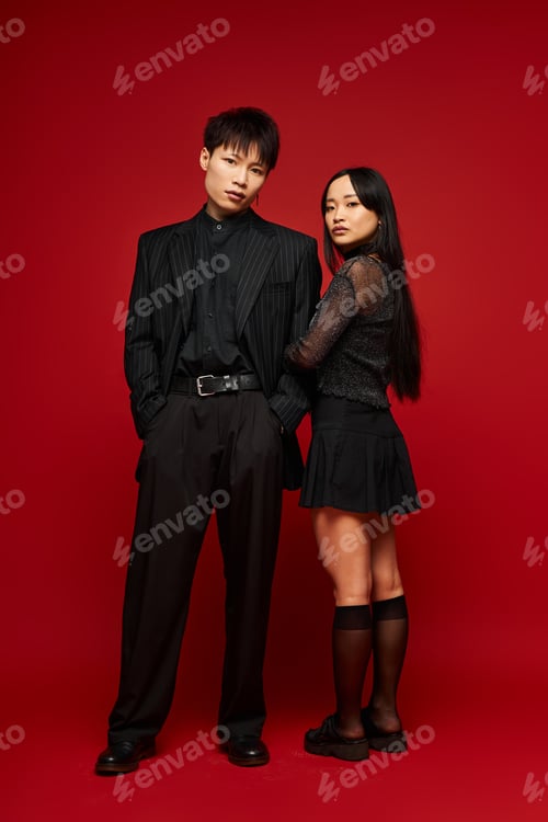 Preview: Stylish couple showcases love and fashion against a vibrant red backdrop