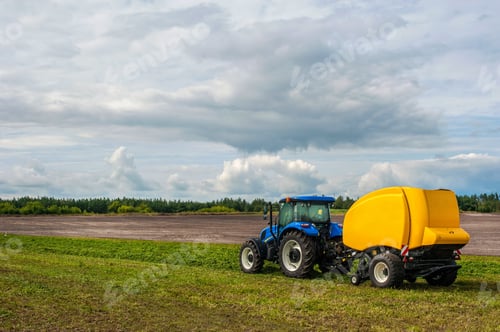 Preview: blue tractor with baler in motion at field work