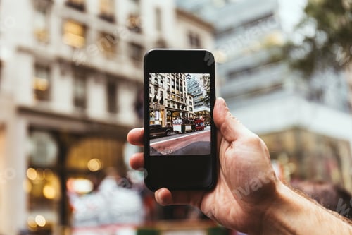 Preview: cropped shot fo man with smartphone taking picture of new york city street