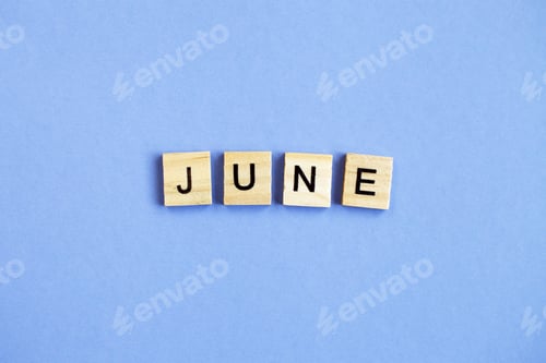 Preview: inscription June made by wooden cubes on a veri peri purple background.