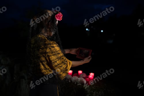 Preview: Woman with Candles Honors Deceased at Night