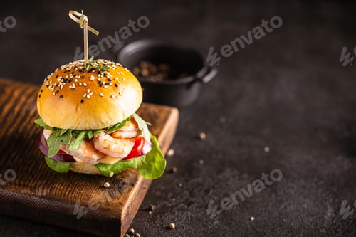 Preview: Burger with shrimps on a wooden board, copy space