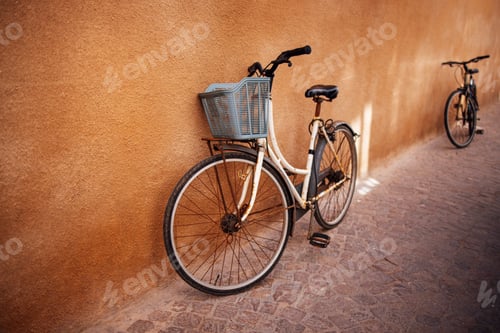 Preview: Vintage bicycle with a blue basket leaning against a textured wall
