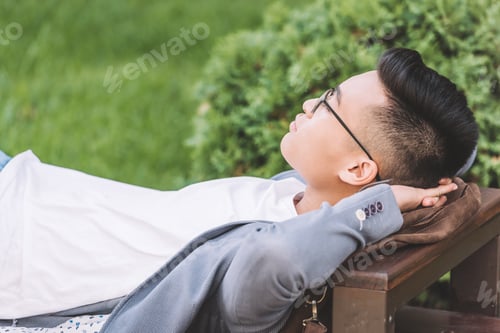 Preview: stylish asian man in eyeglasses sleeping on bench