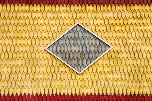 Preview: Old weathered wooden wall with ornament painted in red and yellow. Vintage texture Background.