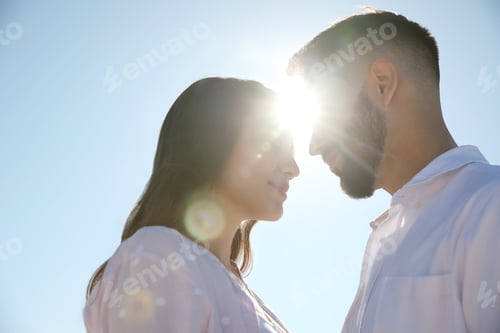 Preview: Happy young couple against blue sky, low angle view. Honeymoon trip