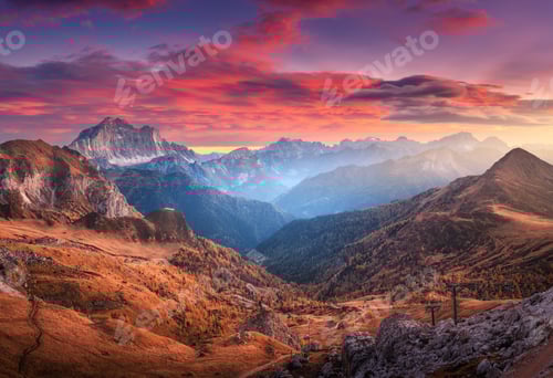 Preview: Colorful red sky with clouds over the beautiful mountains in fog