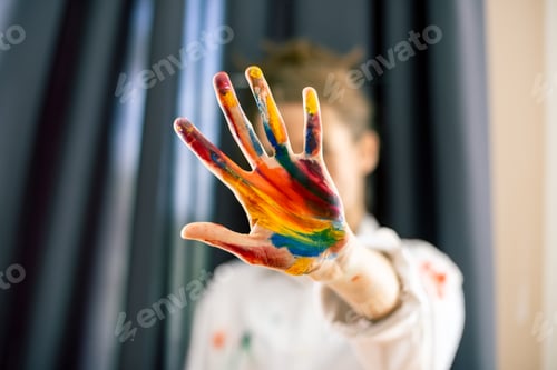 Preview: Woman showing stop gesture, hand painted in colorful paints