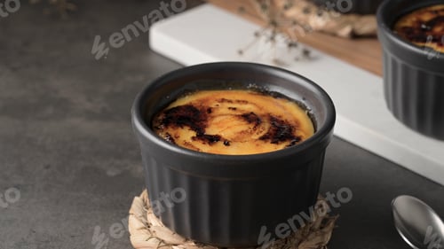 Preview: Crème brûlée in a black ramekin with a caramelized sugar top
