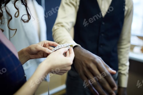 Preview: Tailor Measures Sleeve of Jacket in Workplace