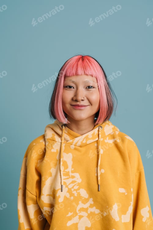 Preview: Asian girl with pink hair and piercing smiling while looking at camera