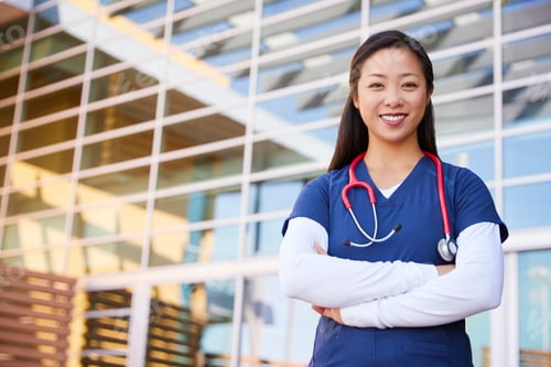 Preview: Smiling Woman in Scrubs with Stethoscope Outdoors