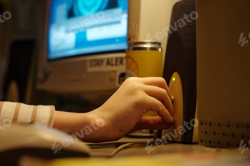 Preview: Hand Turning Speaker Volume Knob in Dimly Lit Room