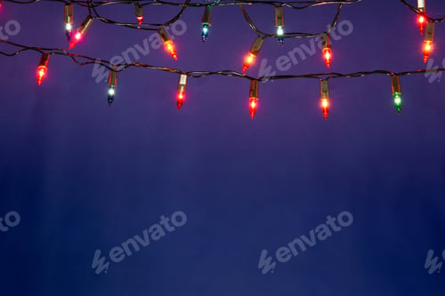 Preview: Christmas lights string on blue background with copy space