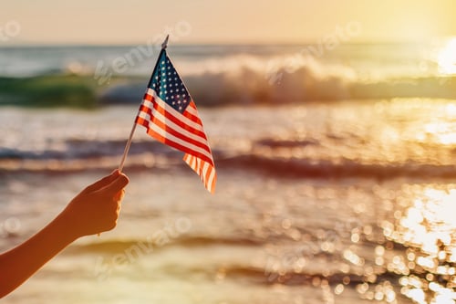 Preview: Candid authentic gen Z boy keep American Flag by hand on sea background as symbol of democracy