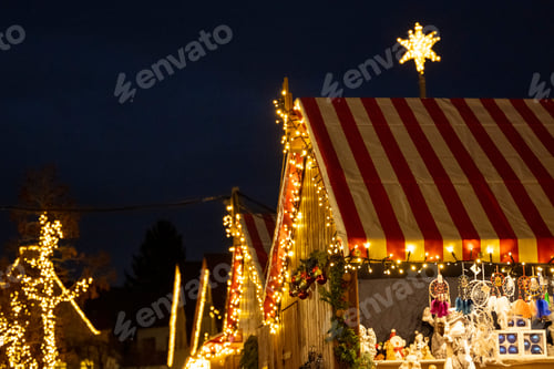 Preview: Regular horizontal shot of colorful booths decorated by lights in a Christmas attraction park