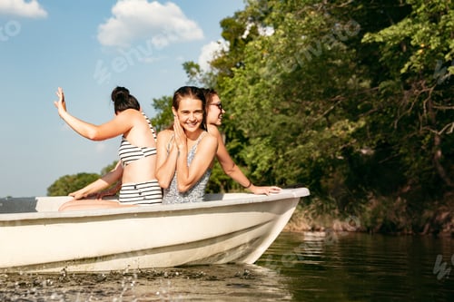 Preview: Happy group of friends having fun, laughting and swimming in river