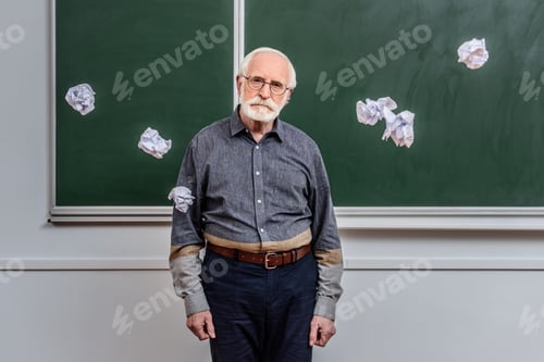 Preview: senior lecturer standing between falling crumpled pieces of paper