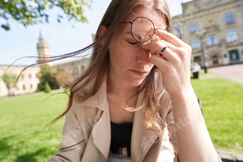 Preview: Tired young woman after working day in park