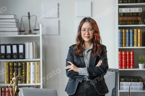 Preview: Young lawyer is standing confidently in her office with her arms crossed