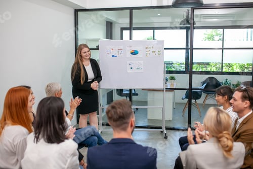 Preview: business team male and female colleagues talking at work share ideas with chart on board.