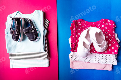 Preview: Folded blue and pink bodysuit. Stack of infant clothing. Child outfit.